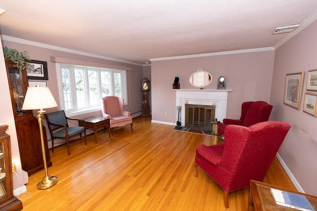 living room with crown molding, hardwood / wood-style flooring, a baseboard radiator, and a tile fireplace