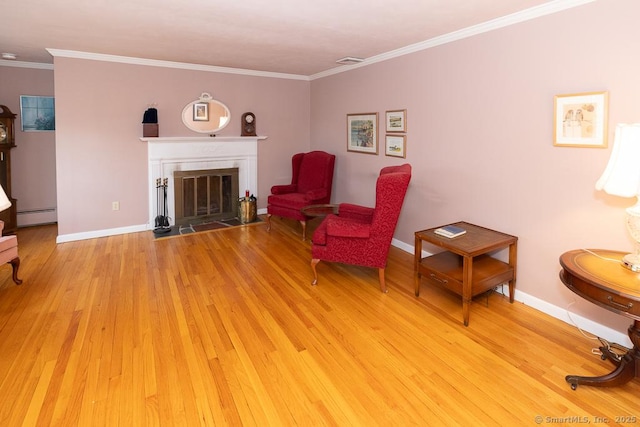 sitting room featuring baseboard heating, crown molding, and light hardwood / wood-style floors