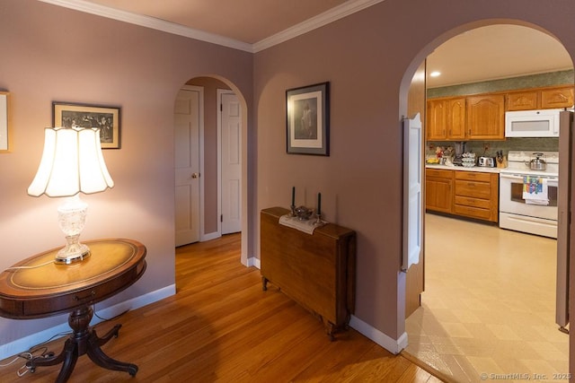 hall with ornamental molding and light wood-type flooring