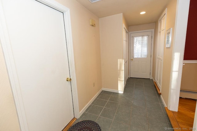 entryway with a baseboard radiator and dark tile patterned floors