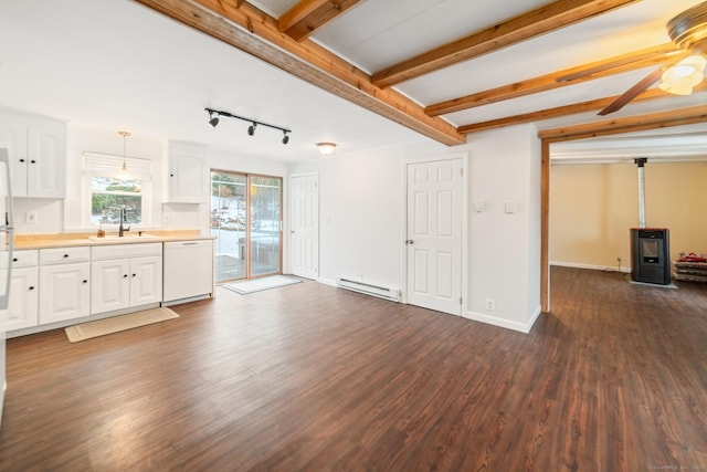 unfurnished living room with sink, a wood stove, dark hardwood / wood-style flooring, a baseboard heating unit, and beam ceiling