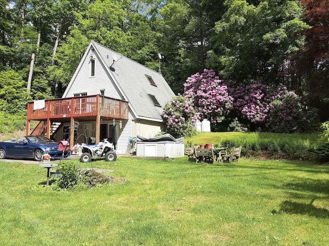 rear view of property featuring a lawn and a wooden deck