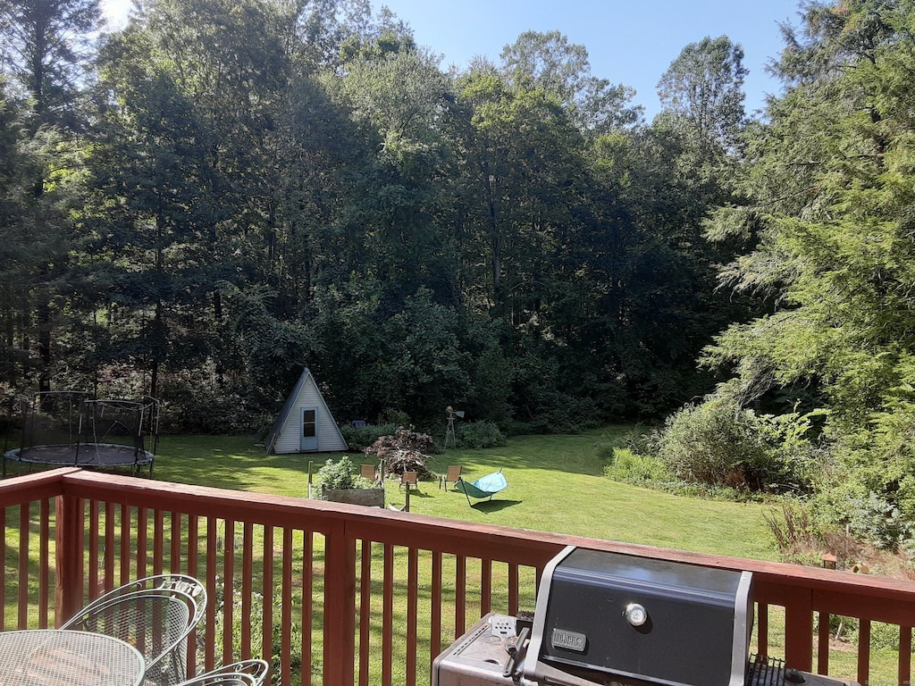 wooden terrace featuring a yard and a trampoline