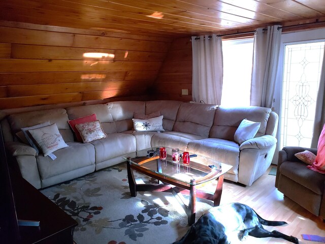 living room featuring light hardwood / wood-style flooring, wood walls, and wood ceiling