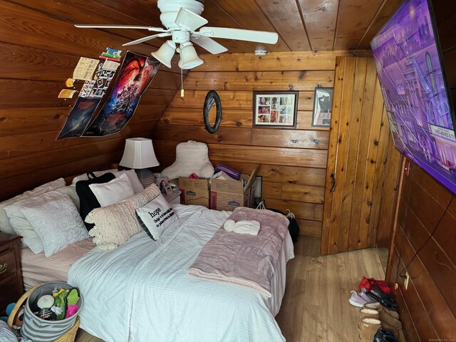 bedroom featuring wooden ceiling, ceiling fan, light wood-type flooring, and wooden walls