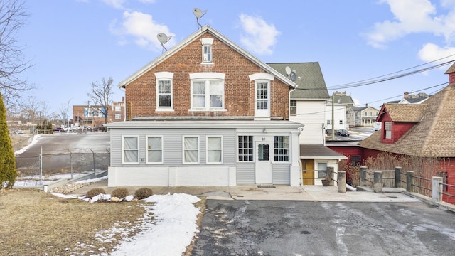 view of front of house with fence and brick siding