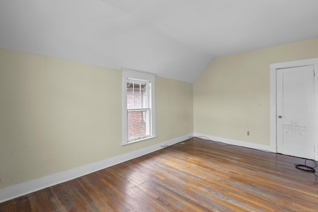 additional living space with lofted ceiling, baseboards, and wood finished floors