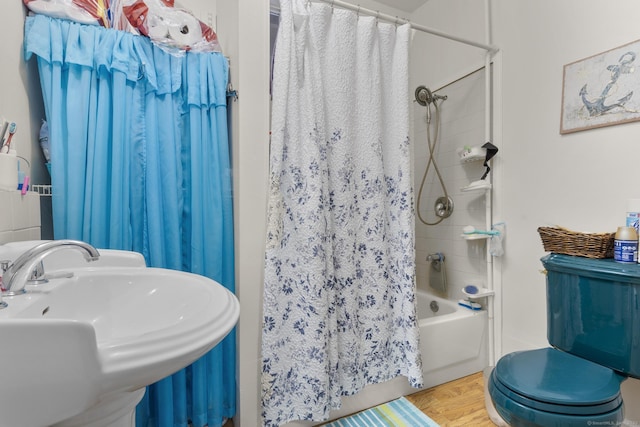 full bathroom featuring shower / bath combination with curtain, a sink, toilet, and wood finished floors