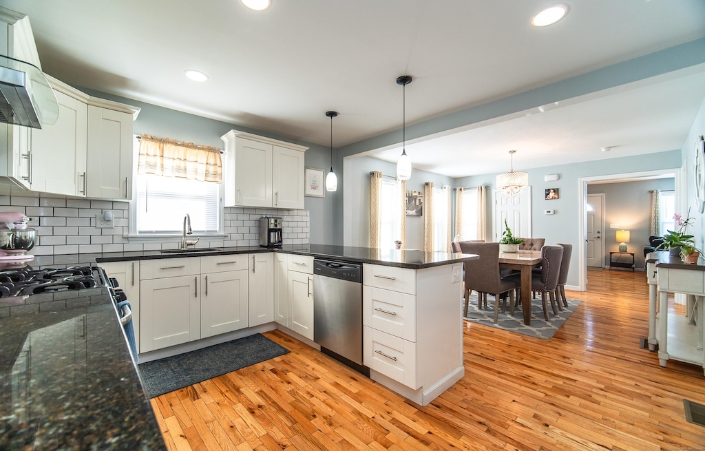 kitchen with white cabinetry, dishwasher, sink, and pendant lighting