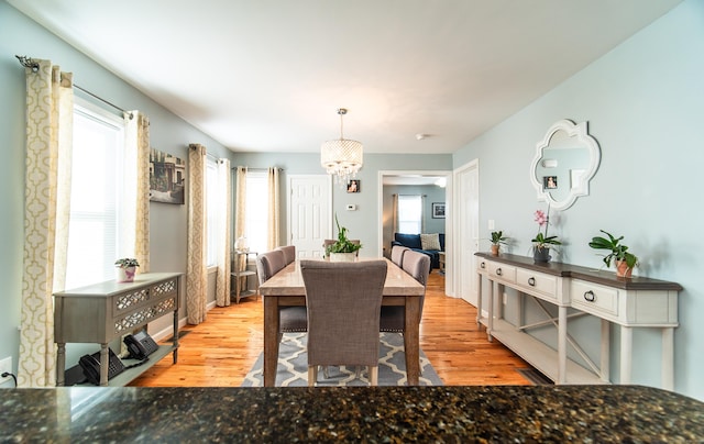 dining area featuring an inviting chandelier and light hardwood / wood-style flooring