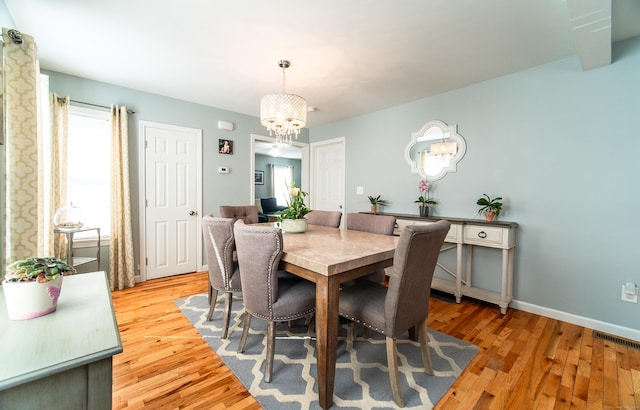 dining area with a chandelier and light wood-type flooring