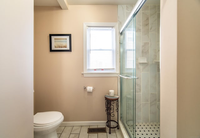 bathroom with tile patterned flooring, a shower with door, and toilet