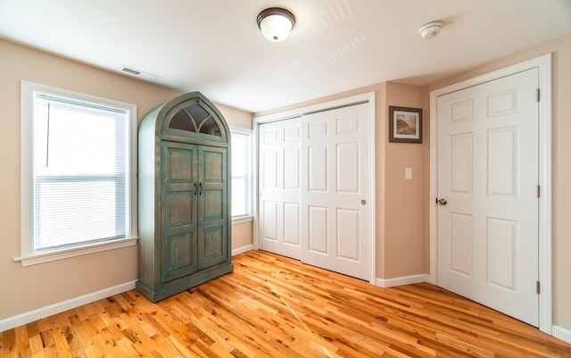 unfurnished bedroom with a closet and light wood-type flooring