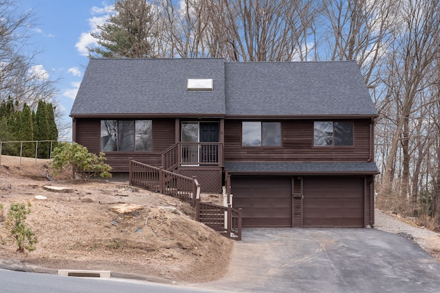 rustic home featuring an attached garage, roof with shingles, and driveway