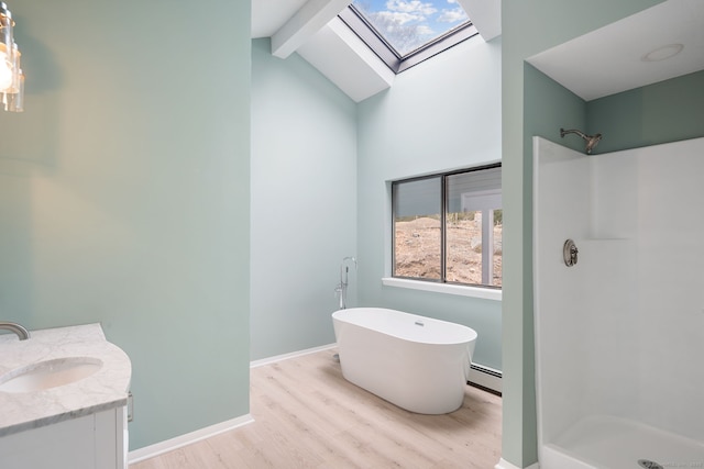 full bathroom with wood finished floors, a stall shower, a freestanding tub, vanity, and a baseboard radiator