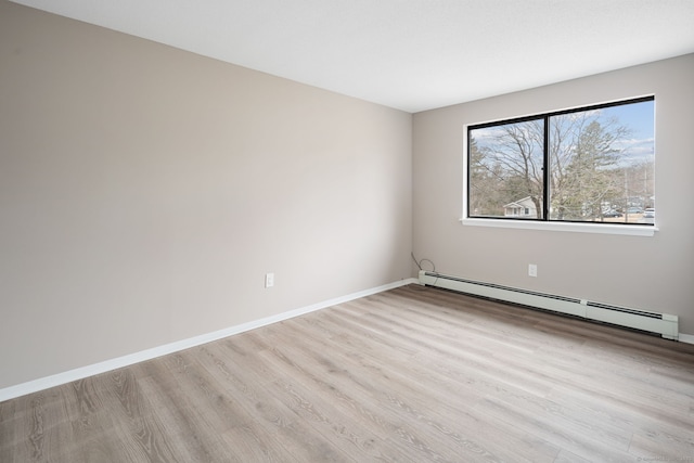 spare room with light wood-style floors, baseboards, and baseboard heating