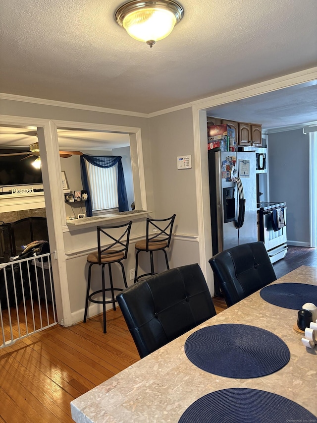 dining space featuring wood-type flooring and a textured ceiling