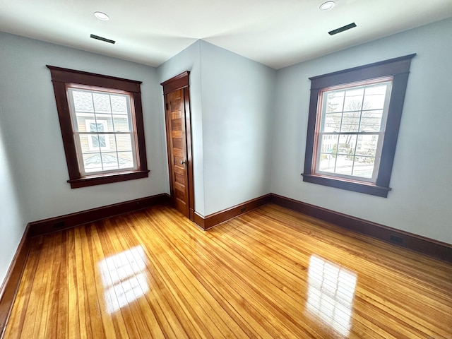 spare room featuring plenty of natural light and light wood-type flooring