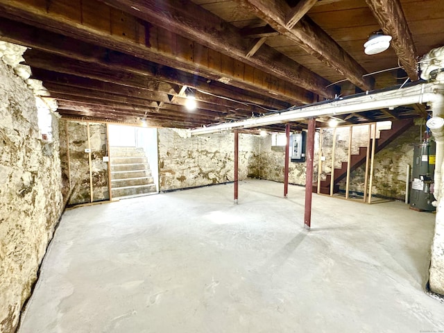 basement featuring electric panel and water heater