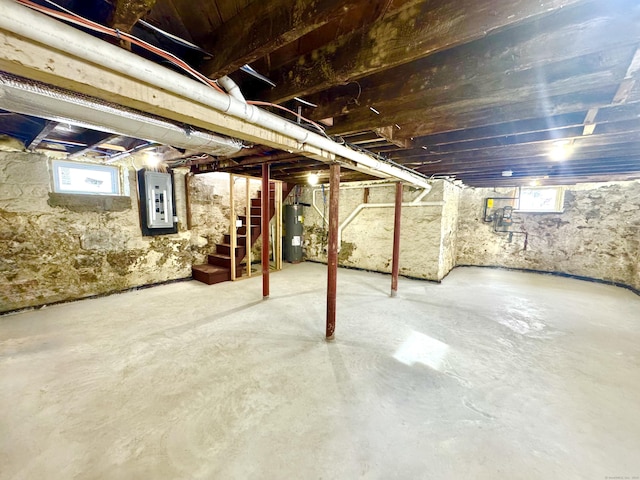 basement featuring electric panel and electric water heater