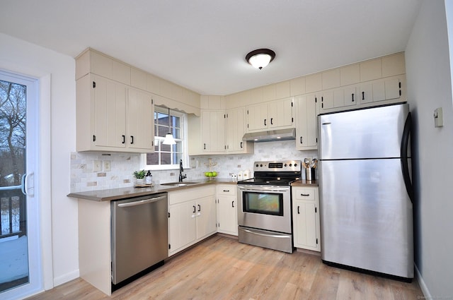 kitchen with tasteful backsplash, sink, stainless steel appliances, and white cabinets