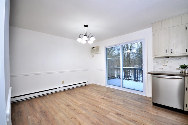 unfurnished dining area featuring a baseboard heating unit, a notable chandelier, a wall unit AC, and light wood-type flooring