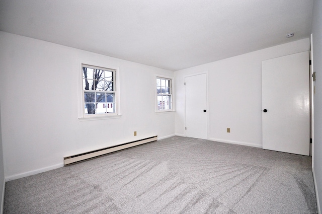 empty room featuring baseboard heating and carpet floors