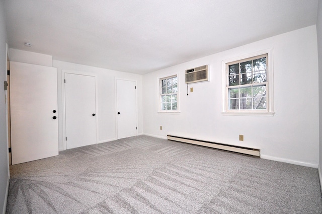 carpeted spare room with a baseboard heating unit and a wall mounted AC