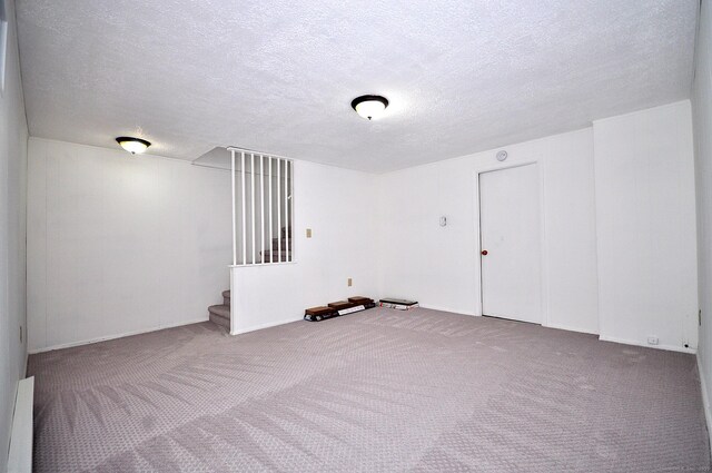 empty room with carpet and a textured ceiling