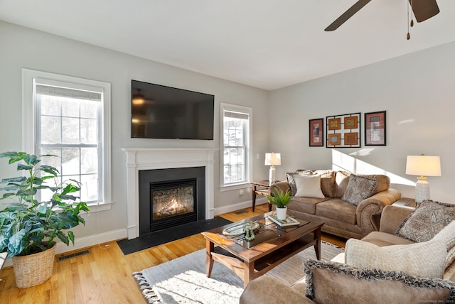 living room featuring ceiling fan, a healthy amount of sunlight, and light hardwood / wood-style floors