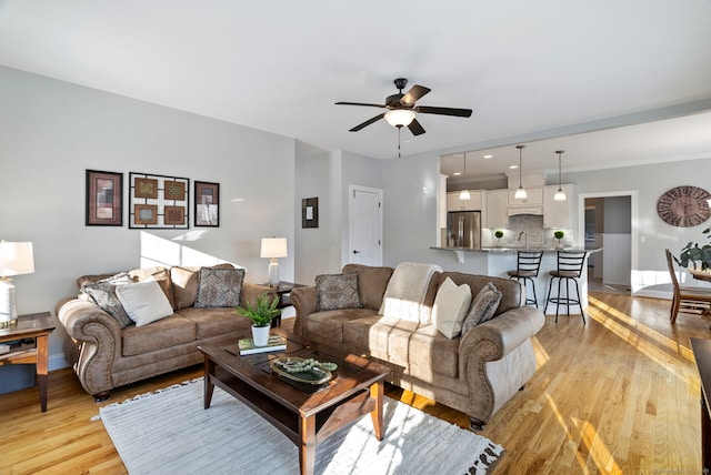 living room with ceiling fan and light hardwood / wood-style flooring