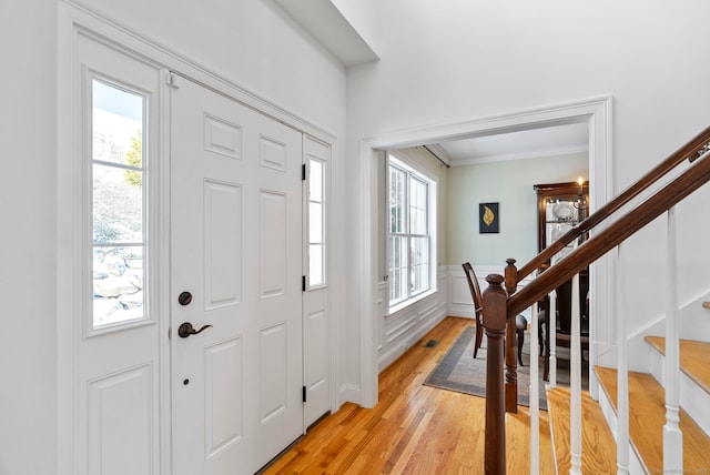 foyer featuring crown molding and light wood-type flooring