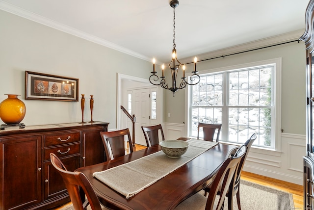 dining area featuring crown molding, light hardwood / wood-style floors, and a chandelier