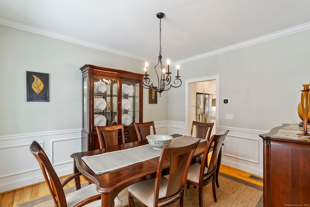 dining room with ornamental molding and light wood-type flooring