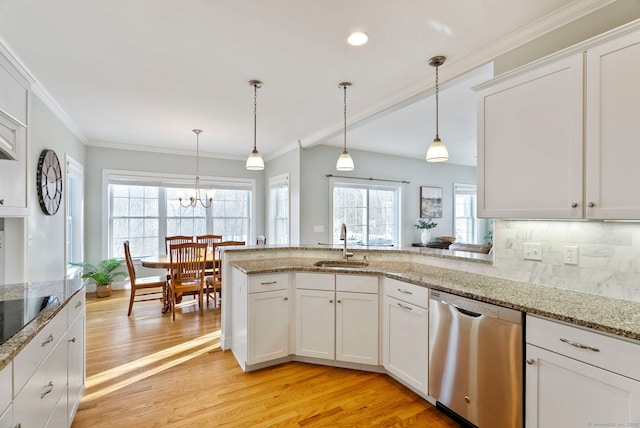 kitchen featuring hanging light fixtures, dishwasher, sink, and white cabinetry