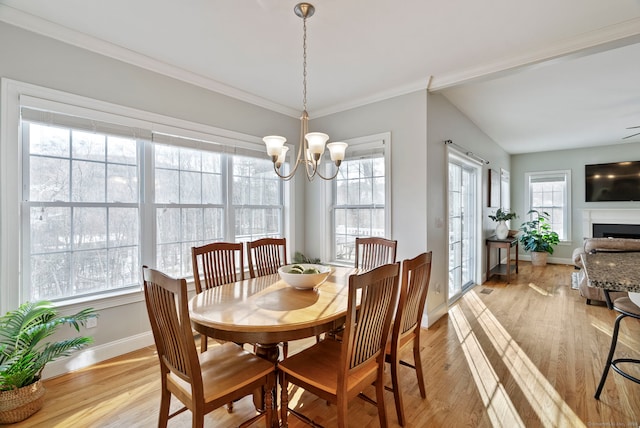 dining area featuring crown molding, light hardwood / wood-style floors, and a chandelier