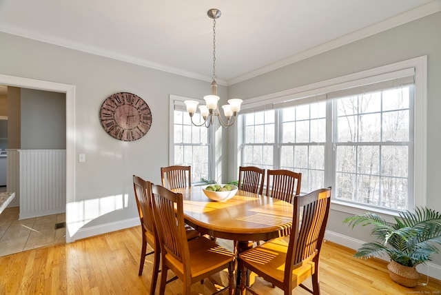 dining room featuring crown molding, a chandelier, and light hardwood / wood-style flooring