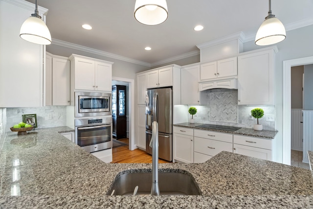 kitchen with stainless steel appliances, white cabinetry, hanging light fixtures, and custom range hood