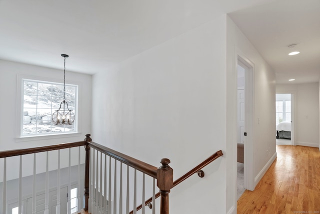 hallway featuring a notable chandelier and light hardwood / wood-style floors