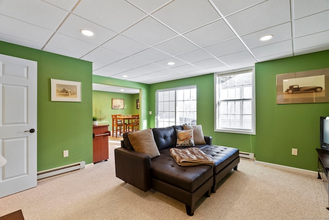 carpeted living room with a baseboard radiator and a paneled ceiling