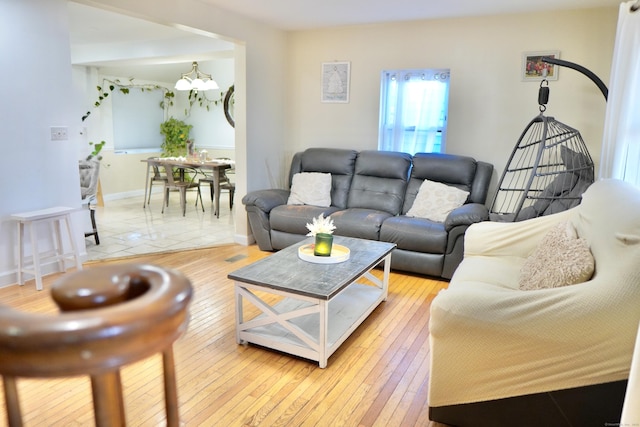 living room featuring an inviting chandelier and light hardwood / wood-style flooring