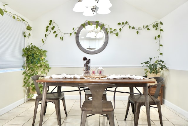 tiled dining area featuring an inviting chandelier and vaulted ceiling