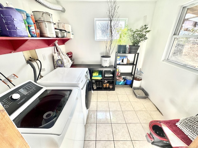 laundry room featuring washing machine and dryer and light tile patterned floors