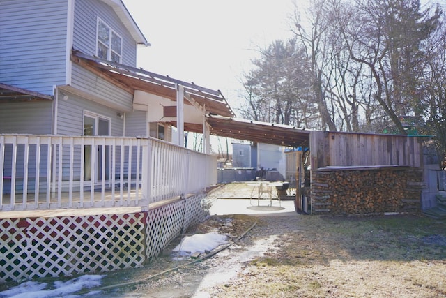 view of property exterior featuring a wooden deck and a patio