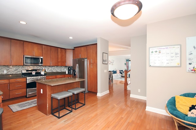 kitchen featuring tasteful backsplash, stainless steel appliances, a kitchen breakfast bar, and a center island