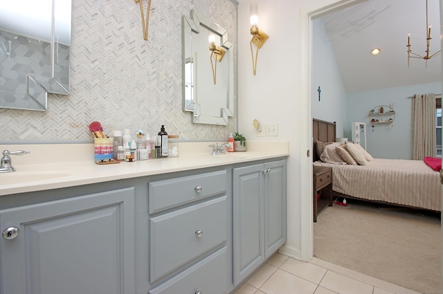 bathroom with tile patterned floors, vaulted ceiling, and vanity