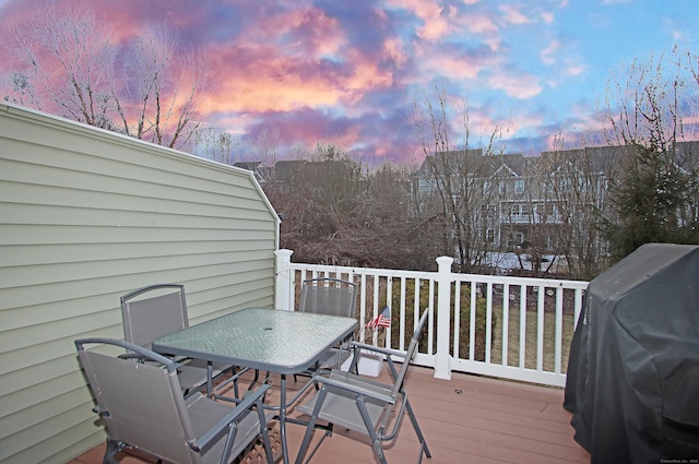 deck at dusk featuring grilling area