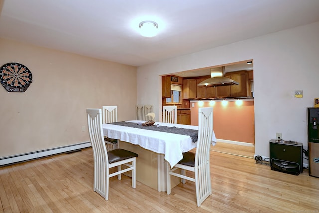 dining area featuring a baseboard radiator and light hardwood / wood-style floors