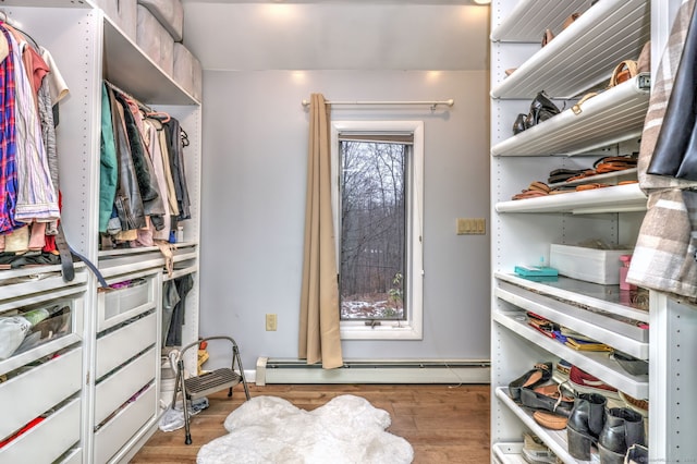 walk in closet with a baseboard heating unit and light wood-type flooring