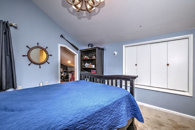 bedroom with lofted ceiling, a chandelier, and carpet